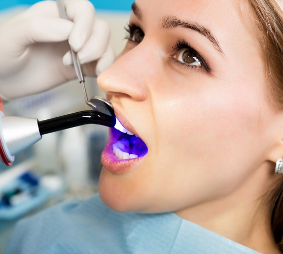 Dental patient having an ultraviolet light shone on their tooth