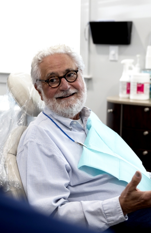 Senior man in dental chair smiling after restorative dentistry in Easton