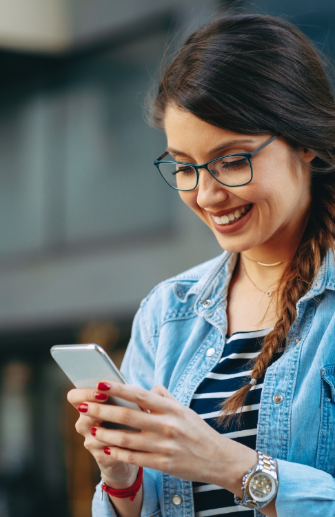 Woman smiling while typing on her phone